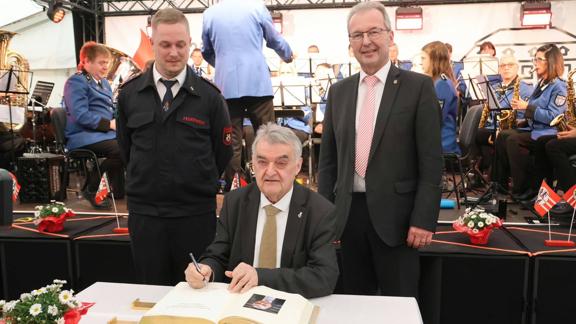 Ins Goldene Buch der Gemeinde Reichshof trug sich NRW-Innenminister Herbert Reul beim Festkommers der Löschgruppe Denklingen ein. Links Einheitsführer Kilian Siepe, rechts Bürgermeister Rüdiger Gennies.