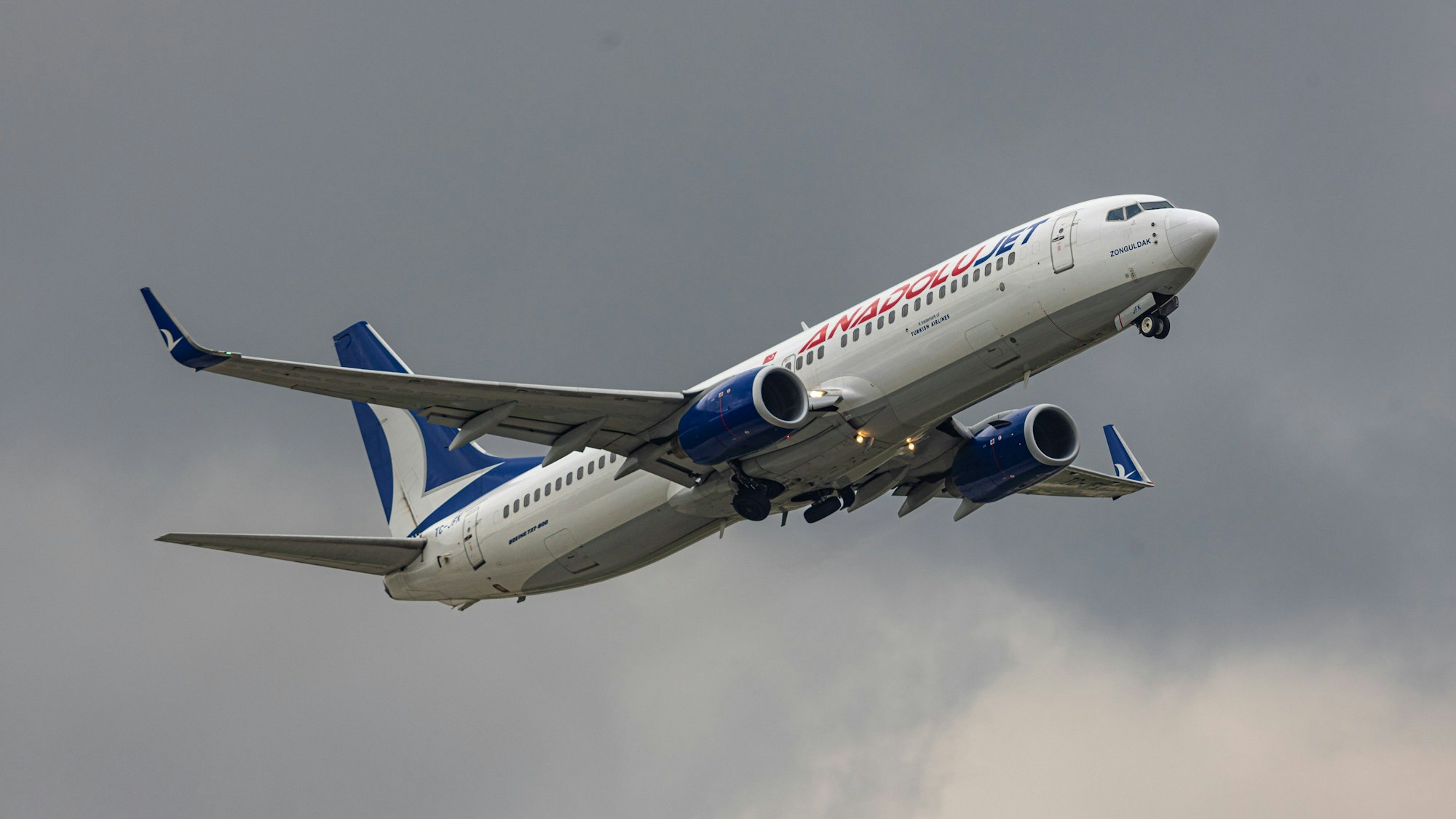 Eine Boeing 737 der türkischen Fluggesellschaft Ajet kurz nach dem Start in einem Unwetter. Das Flugzeug ist vor grauen Gewitterwolken im Steigflug. (Symbolbild)