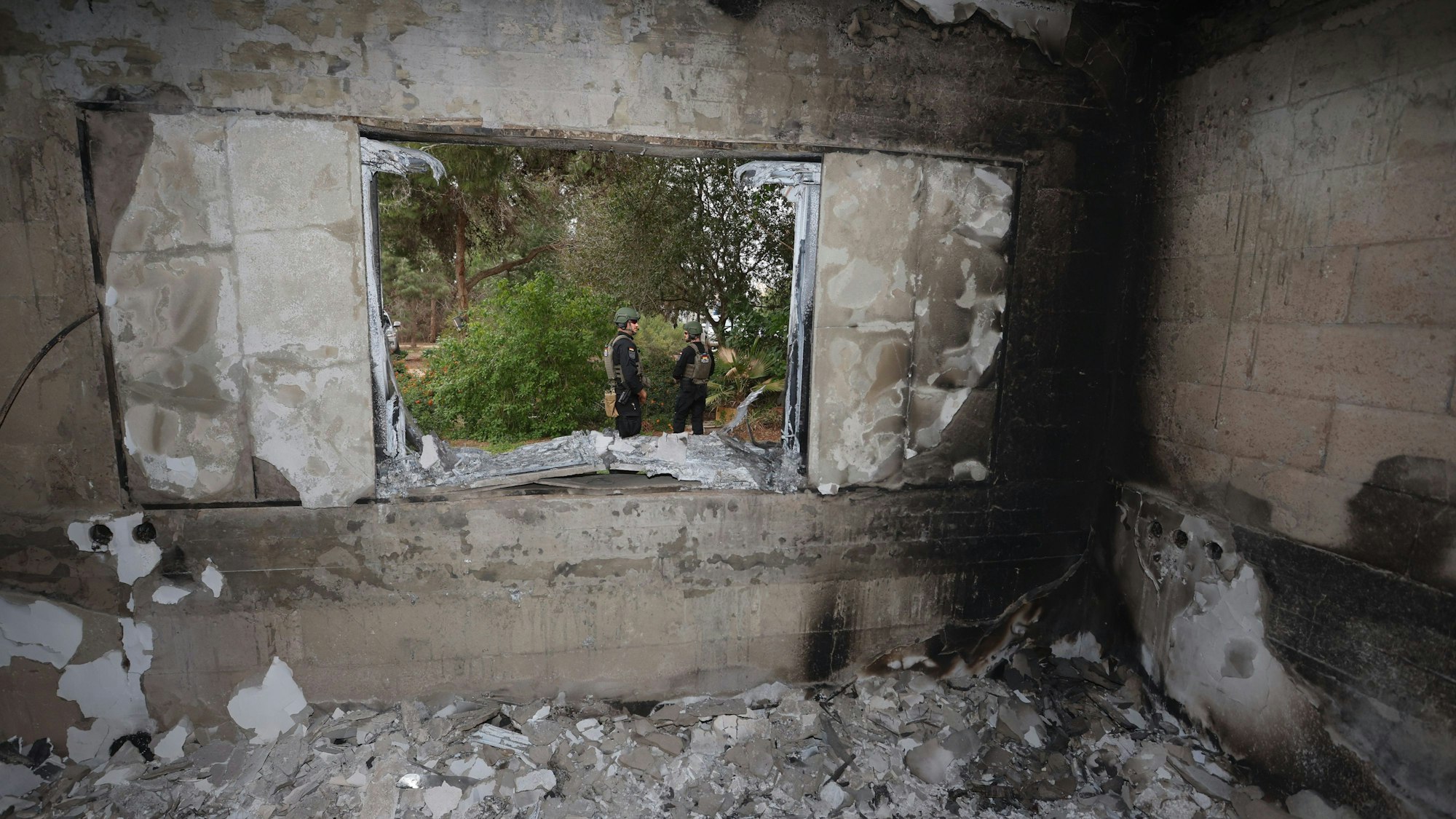 Dezember 2023: Polizisten stehen im Kibbuz Nir Oz im Garten eines zerstörten Hauses.