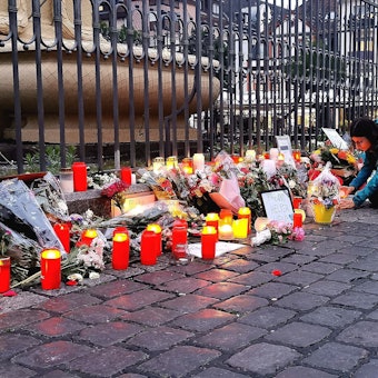 Nach dem Bekanntwerden vom Tod des Polizisten legen am Tatort am Marktplatz Passanten Blumen nieder und zünden Kerzen an. Der Polizist war hier von einem Mann mit einem Messer niedergestochen und lebensgefährlich verletzt worden.