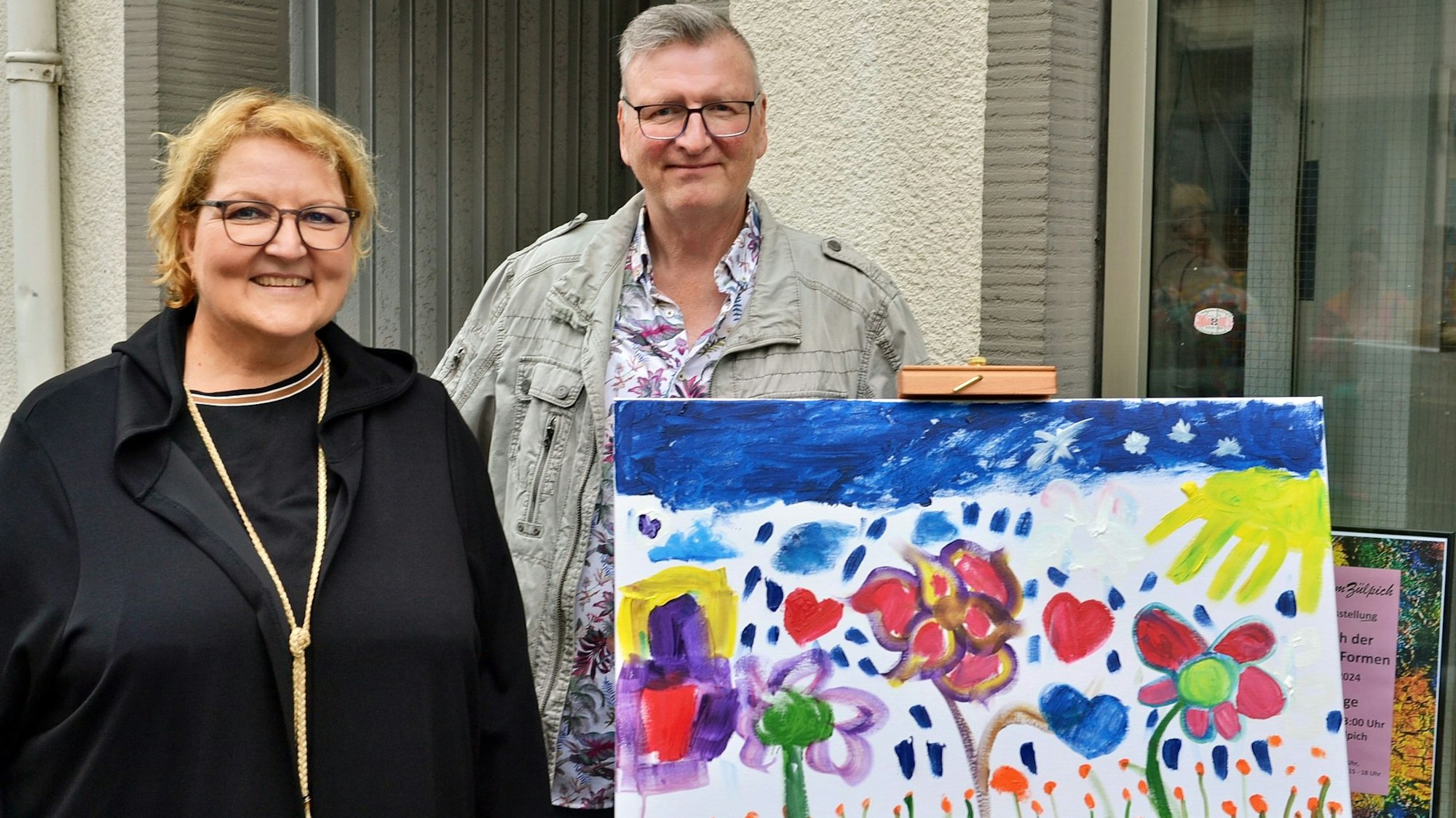 Bettina Böhm und Andreas Zimmermann zeigen die Leinwand, auf der die Besucher sich künstlerisch betätigten.