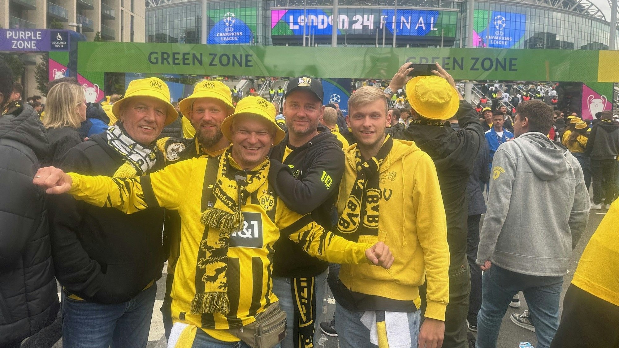 Fünf Männer in Dortmunder Fan-Kleidung stehen gemeinsam vor dem Wembley-Stadion in London.