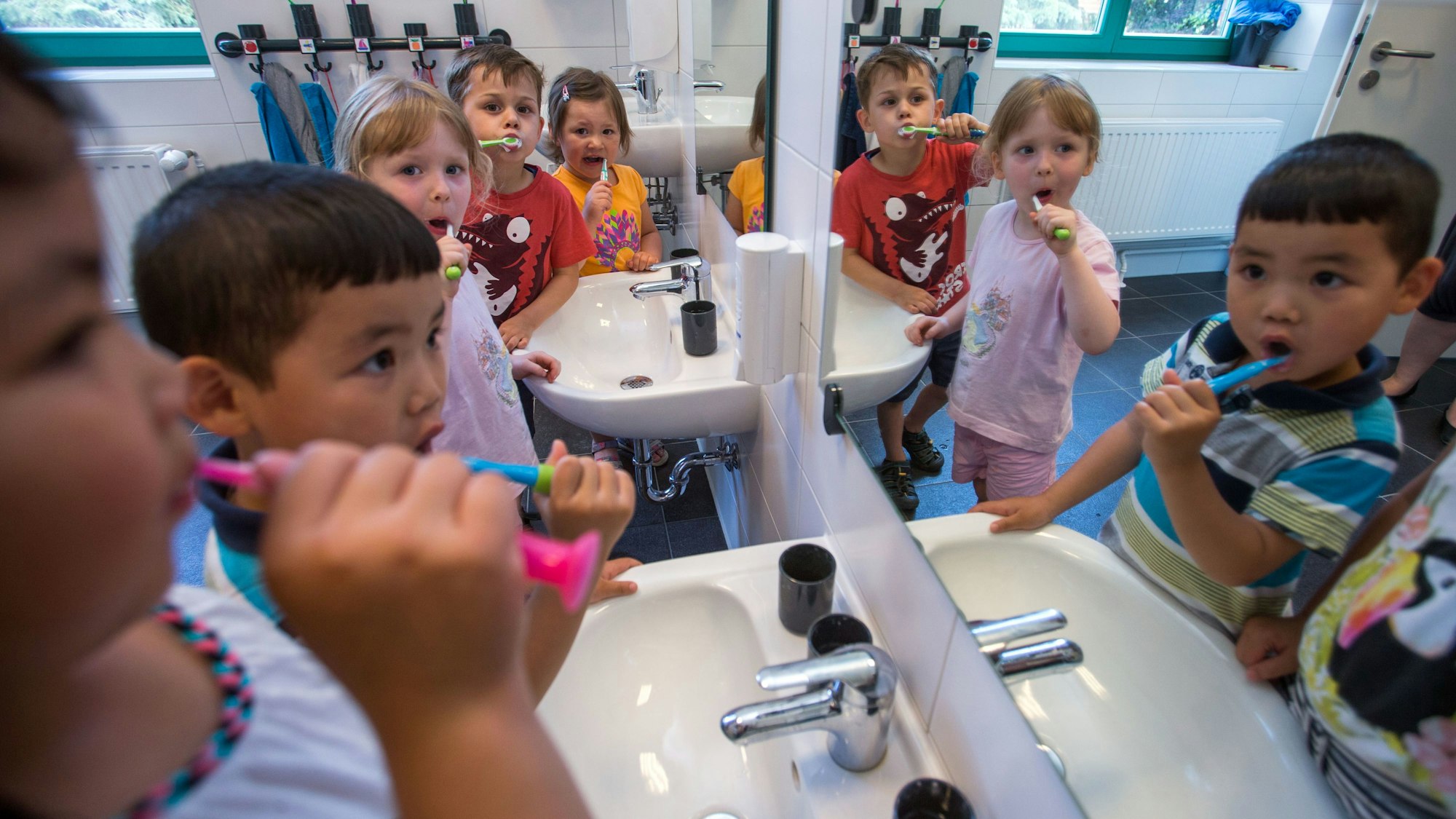 Kleinkinder, die in der Kita übernachten, putzen sich in Schwerin (Mecklenburg-Vorpommern) ihre Zähne.