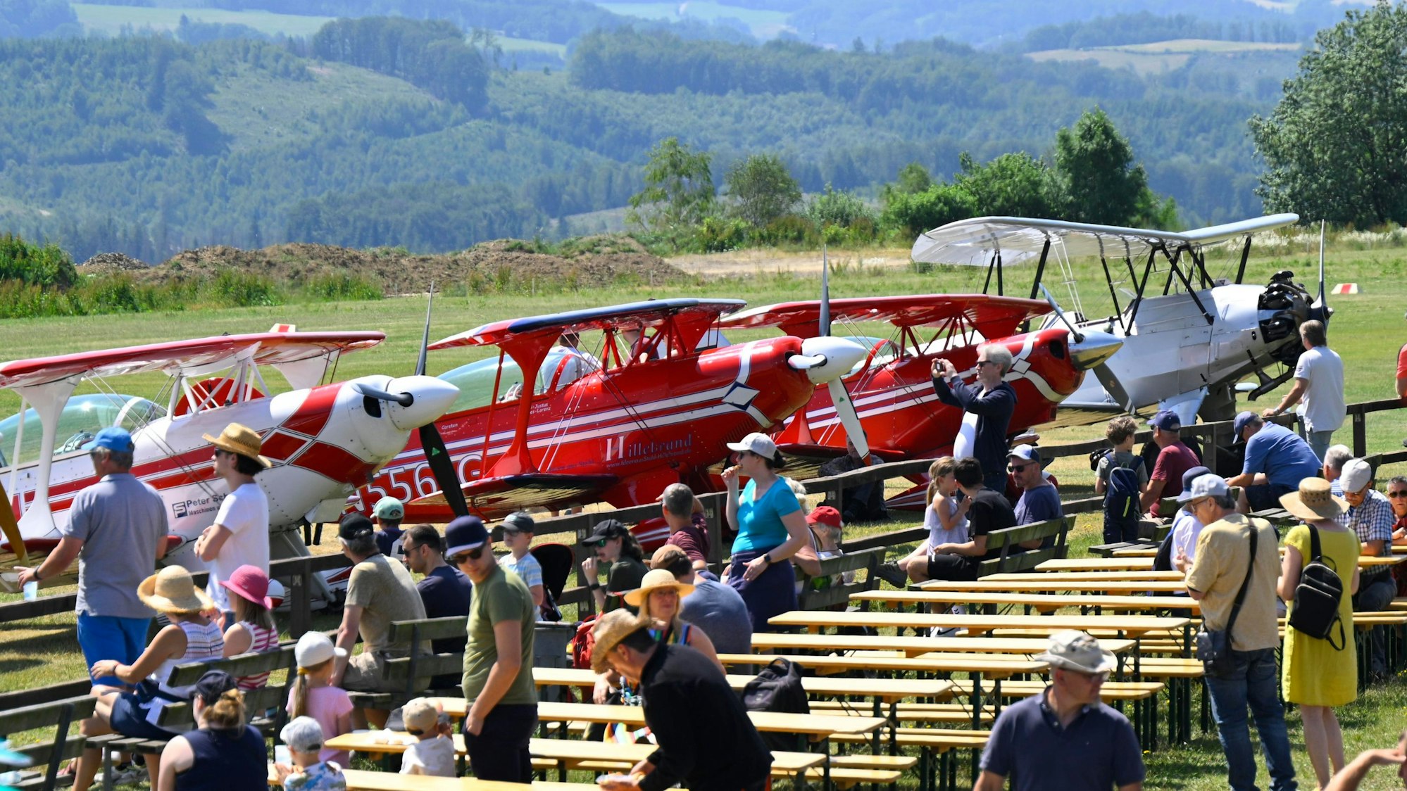 Blick auf das Gelände mit Besuchern und Flugzeugen beim Flugplatzfest in Bergneustadt.