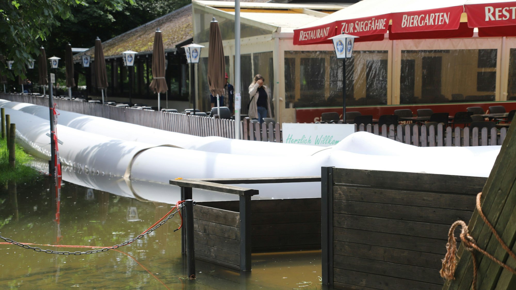 Ein Damm aus zwei Schläuchen schützt ein Gebäude vor Hochwasser.