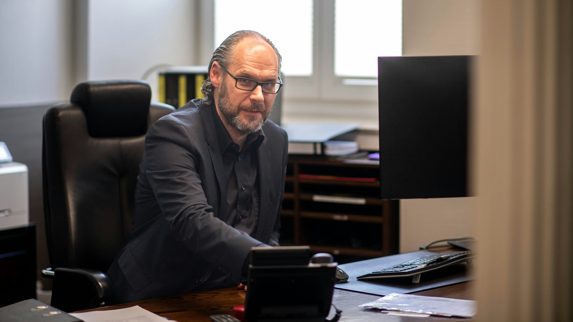 Helmut Häfner sitzt am Schreibtisch.