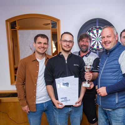 Übergabe eines Pokals an eine Männergruppe