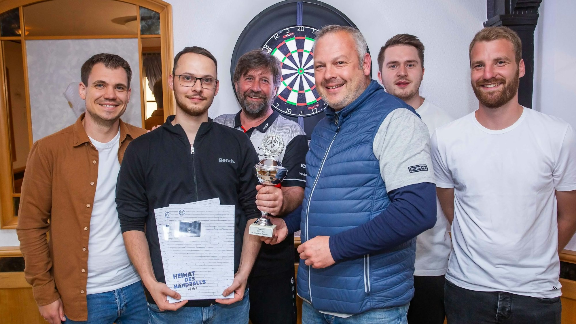 Übergabe eines Pokals an eine Männergruppe