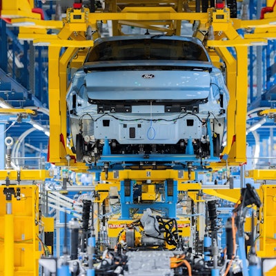 Ford Elektroautos vom Typ Explorer stehen beim Produktionsstart in der Halle.