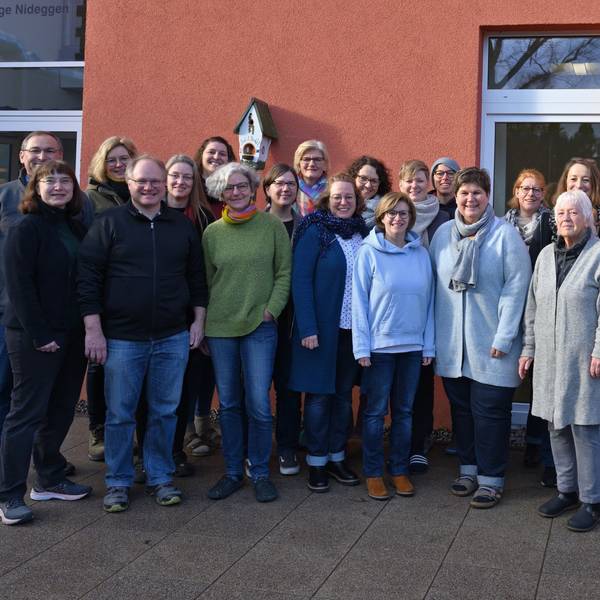 Eine Gruppe von Frauen und Männern steht vor dem Pfarrheim.