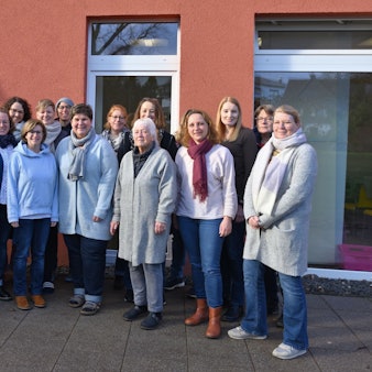 Eine Gruppe von Frauen und Männern steht vor dem Pfarrheim.