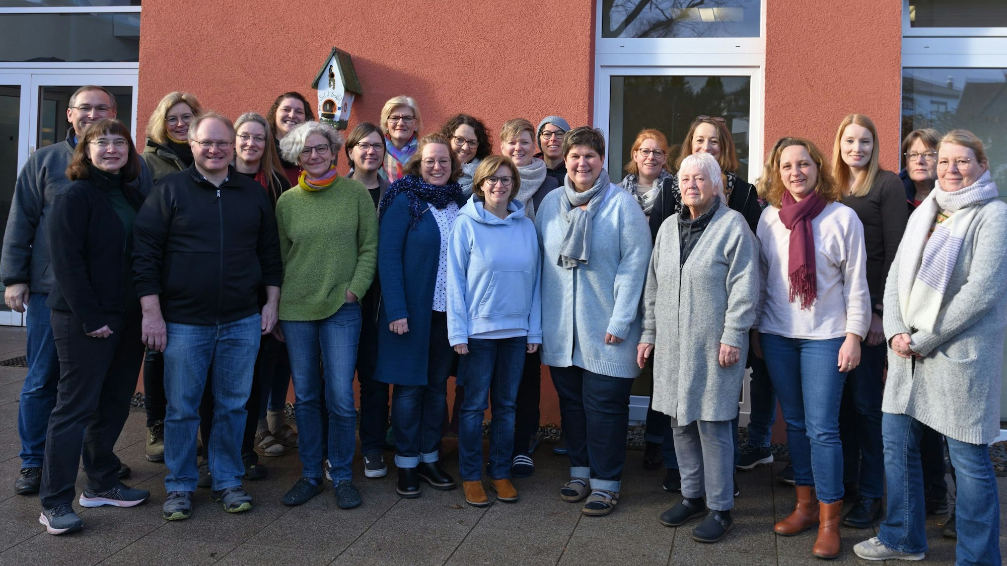 Eine Gruppe von Frauen und Männern steht vor dem Pfarrheim.