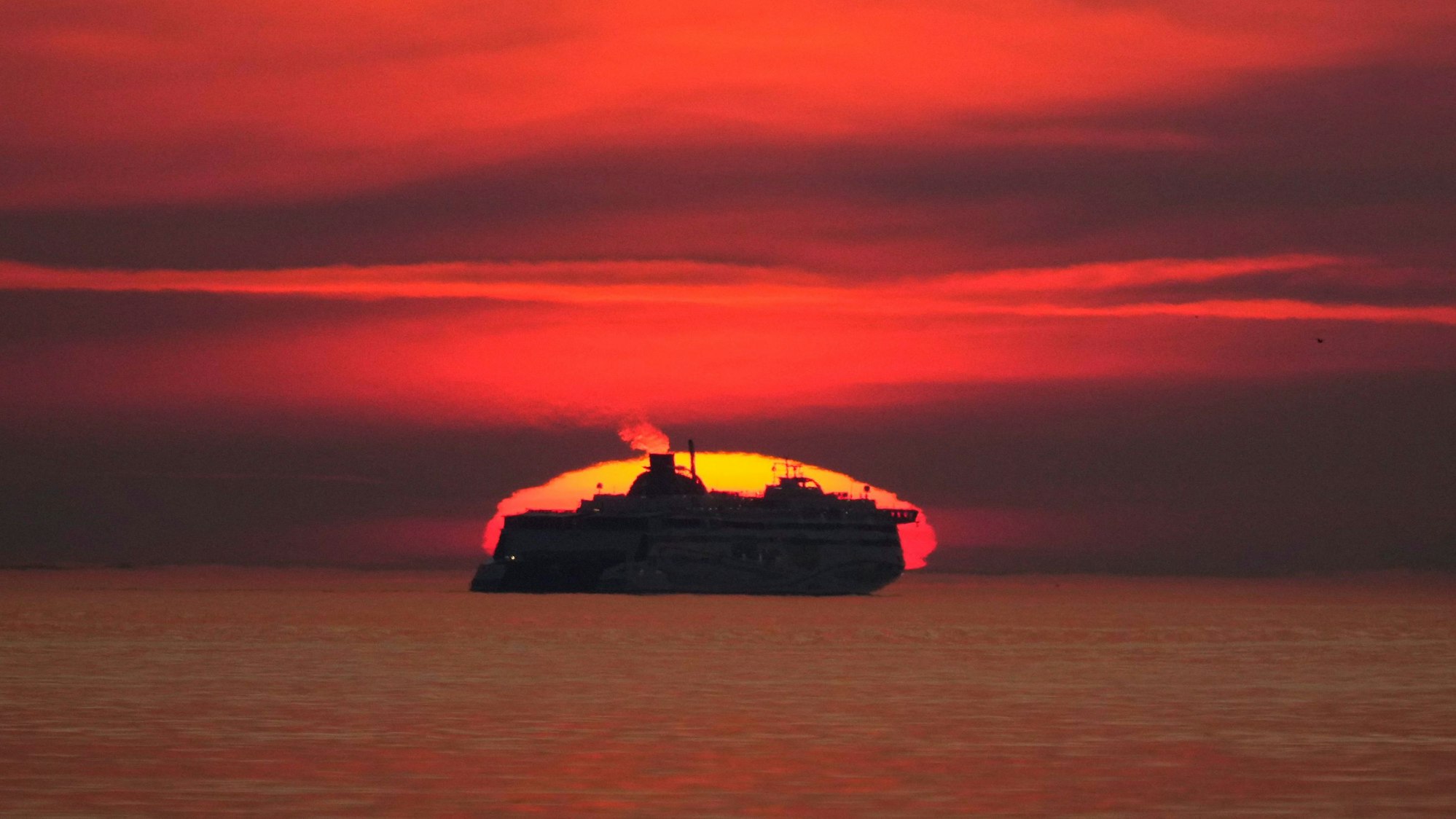 Ein Kreuzfahrtschiff fährt während des Sonnenuntergangs auf der Ostsee über das Meer vor der Küste Estlands.
