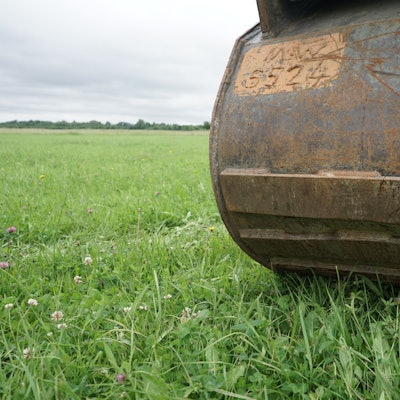 Eine Baggerschaufel auf der Wiese, auf der die neue Erfttrasse entstehen soll.