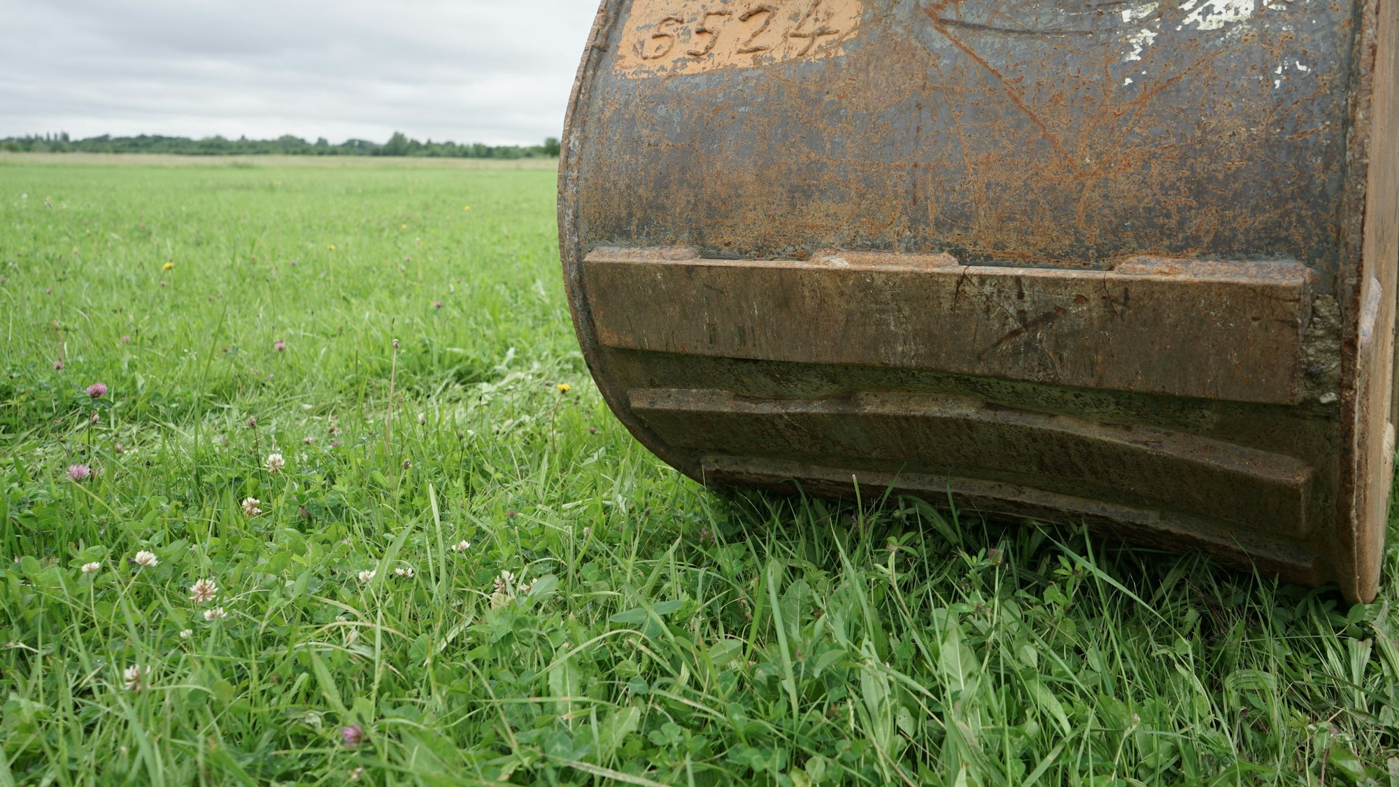 Eine Baggerschaufel auf der Wiese, auf der die neue Erfttrasse entstehen soll.