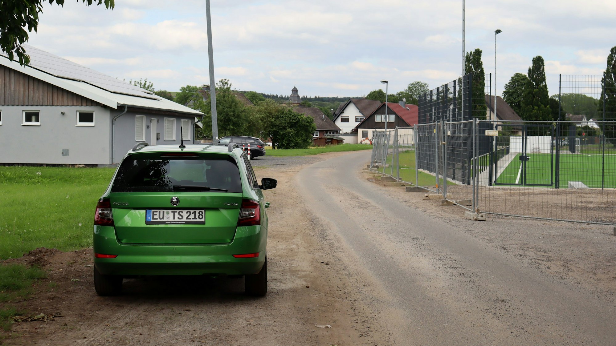Ein Auto parkt an der Straße Im Floting, die zwischen Sportplatz und Musikheim herführt. Wenn es nach dem Willen der Politik geht, soll die Straße hinter das Musikheim verlegt werden.