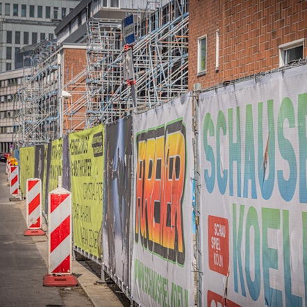 Bauzaun, Gerüst und Baken stehen an der Bühnen-Baustelle.
