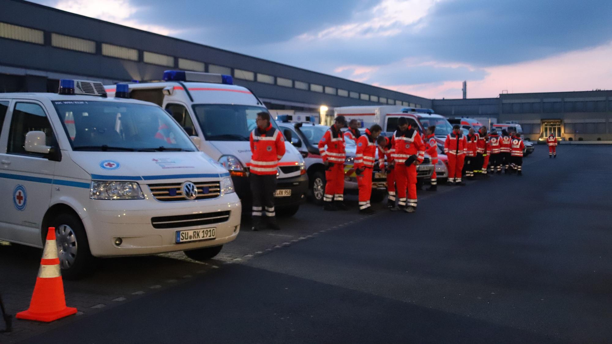 Einsatzkräfte der Wasserwacht des Deutschen Roten Kreuzes stehen vor ihren Fahrzeugen.
