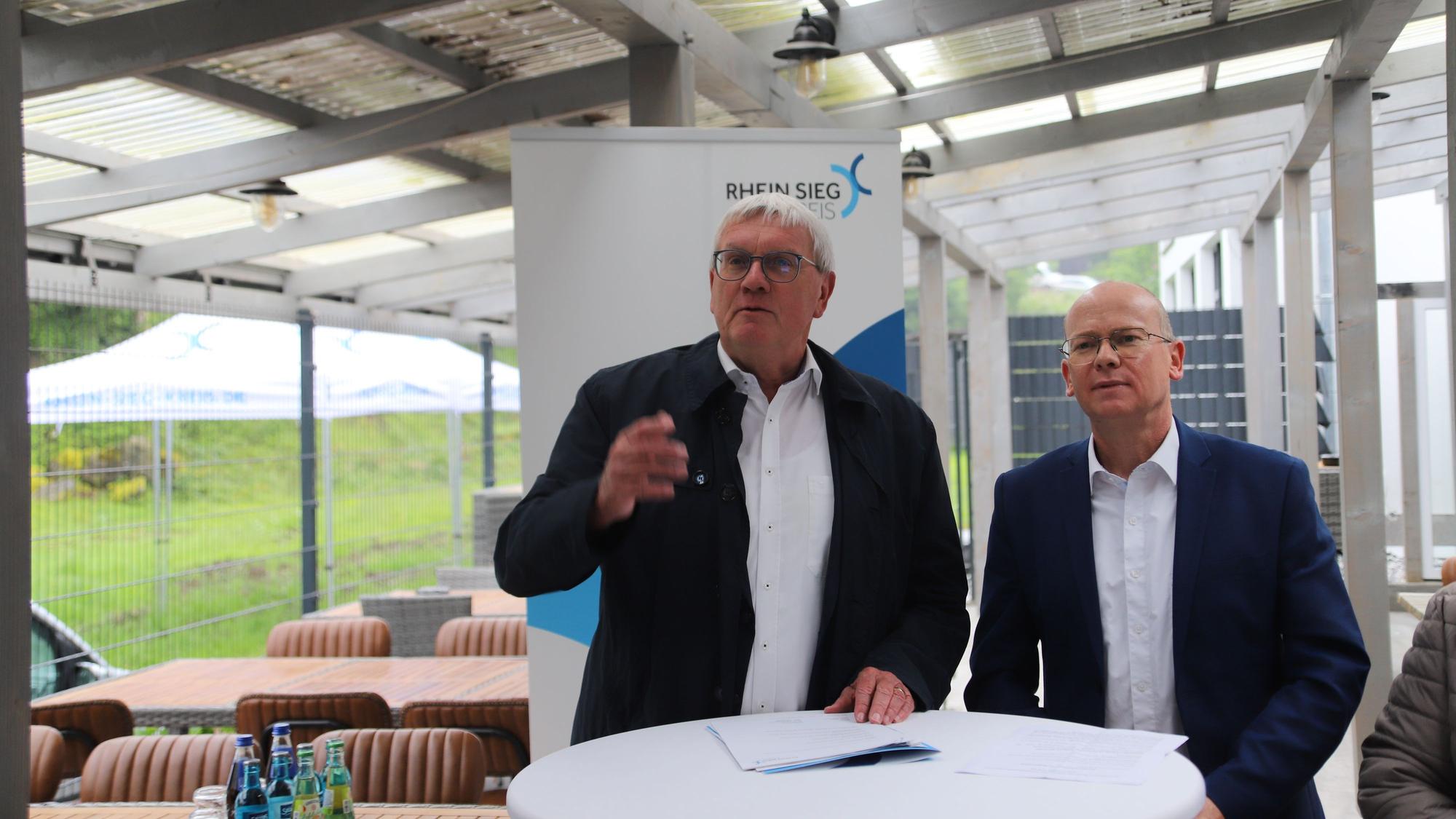 Landrat Sebastian Schuster (l.) und Bürgermeister Mario Loskill stehen an einem Rednerpult.