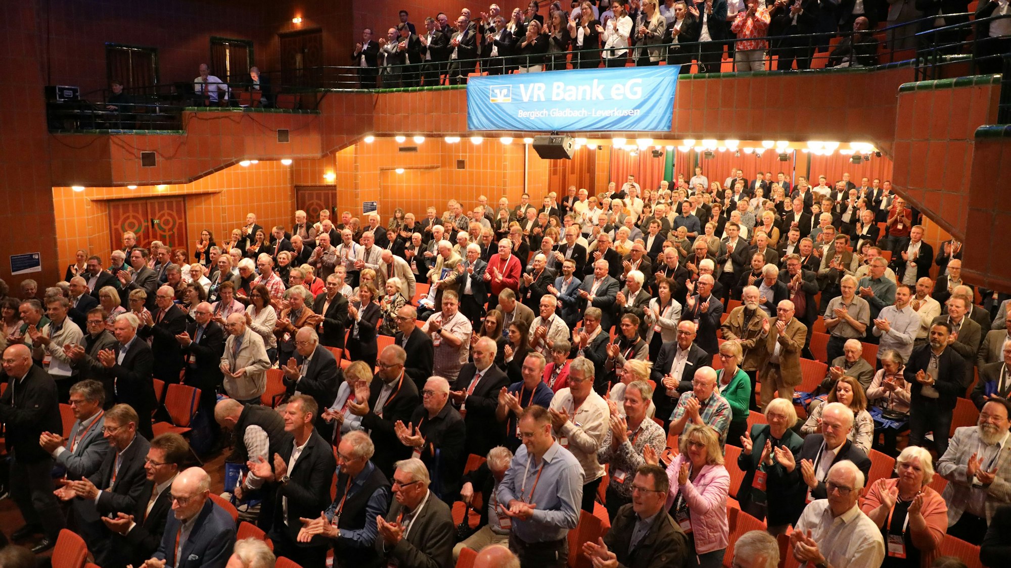 Vertreter der VR Bank Bergisch Gladbach-Leverkusen spenden Applaus im Stehen für den scheidenden Vorstandsvorsitzenden Lothar Uedelhoven.