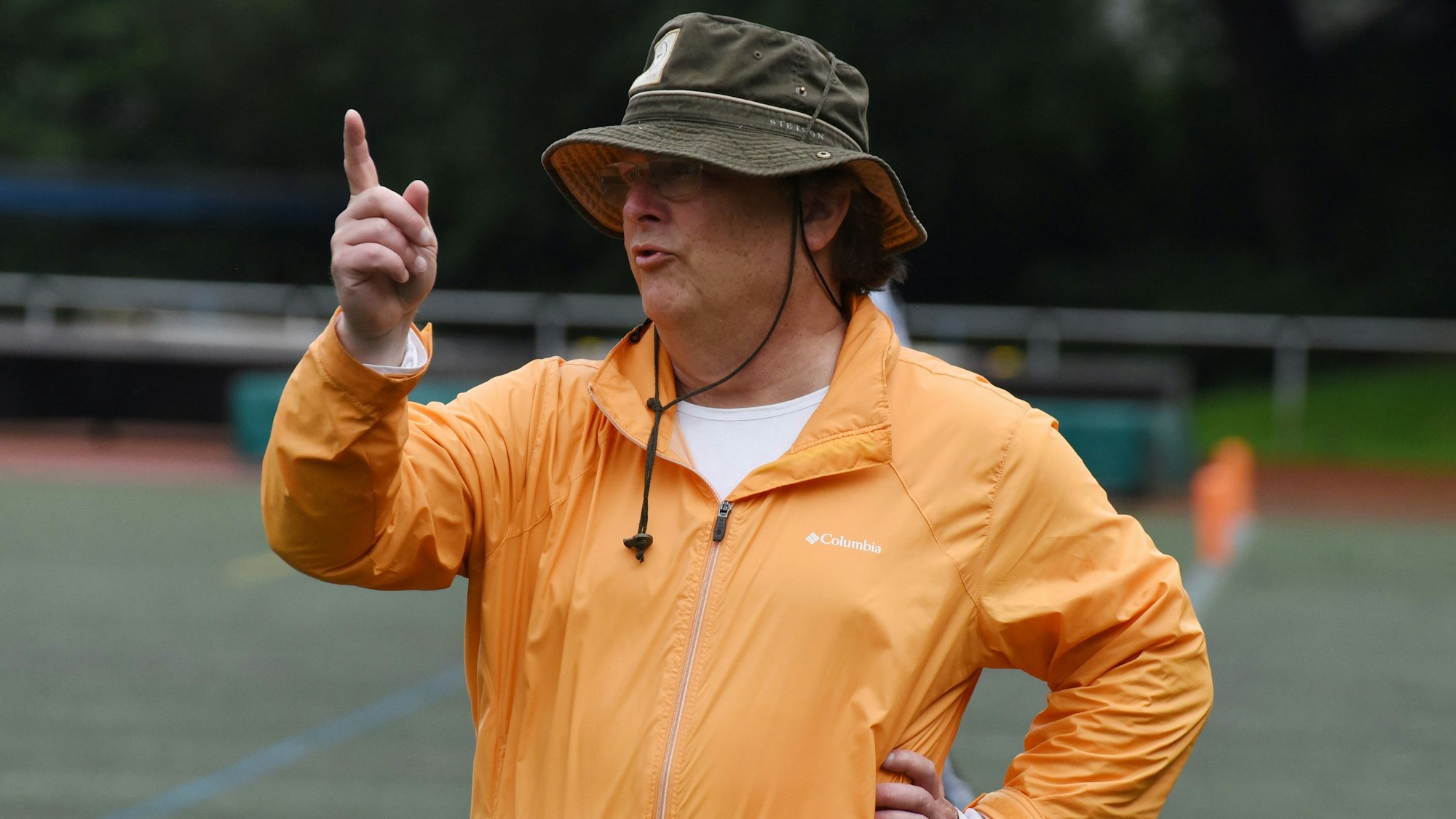 Ein Football-Trainer steht während eines Spiels am Spielfeldrand.
