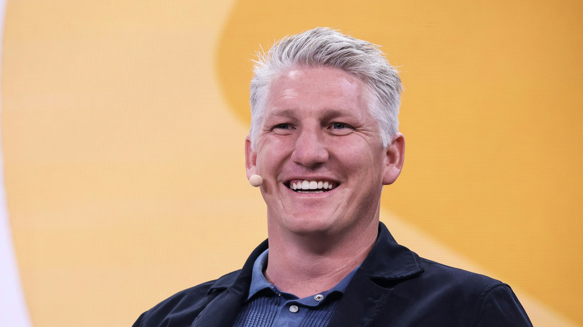 Bastian Schweinsteiger, Fußballexperte ARD, lächelt bei einer Gesprächsrunde auf einer Bühne auf der Digital- und Marketingmesse OMR in den Messehallen.