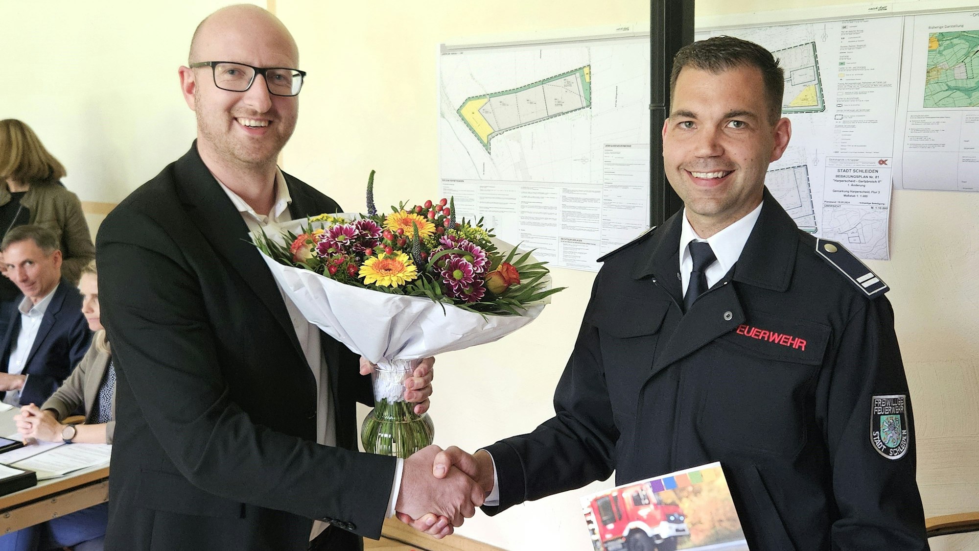 Ingo Pfennings (l.) überreicht Sebastian Hörnchen einen Strauß Blumen.