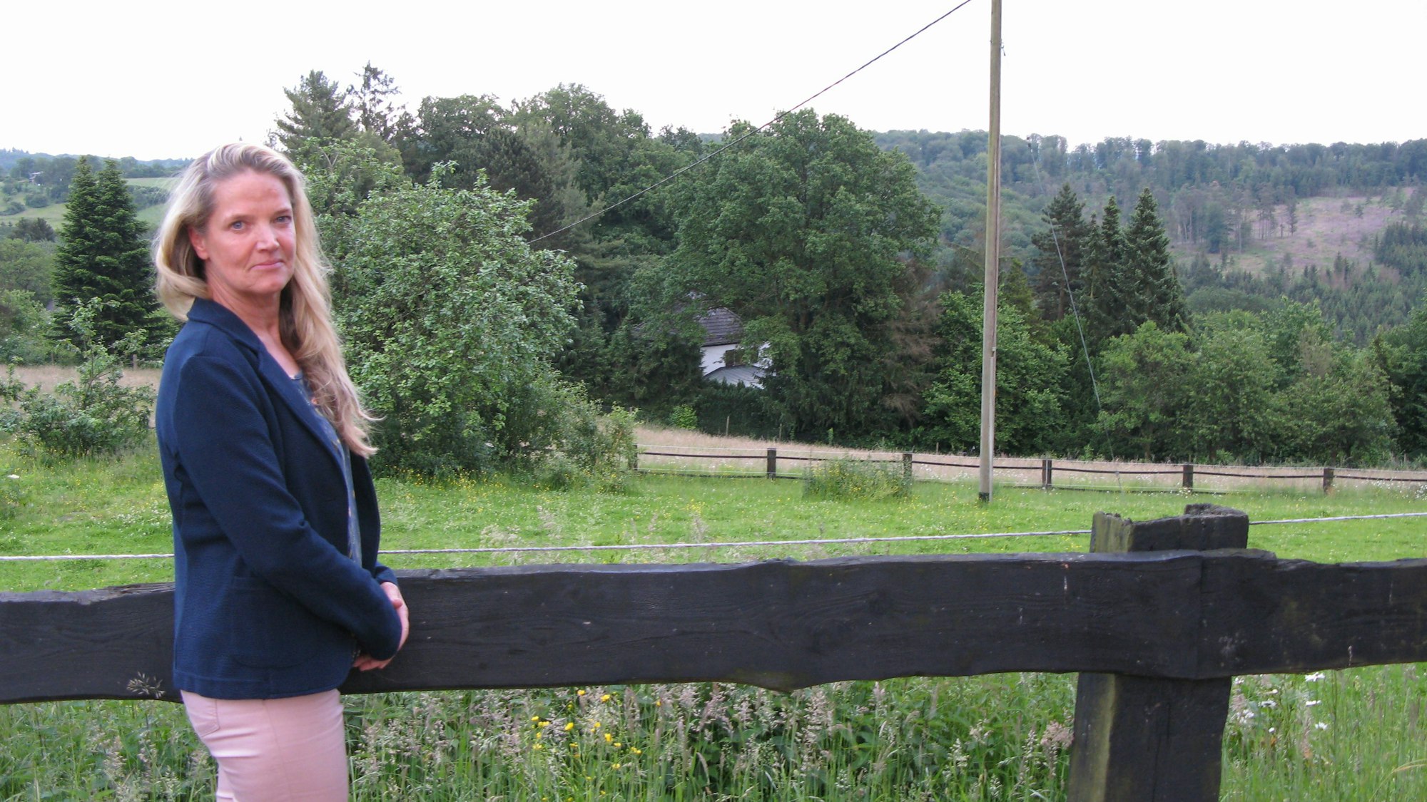 Eine Frau steht vor einem Feld.