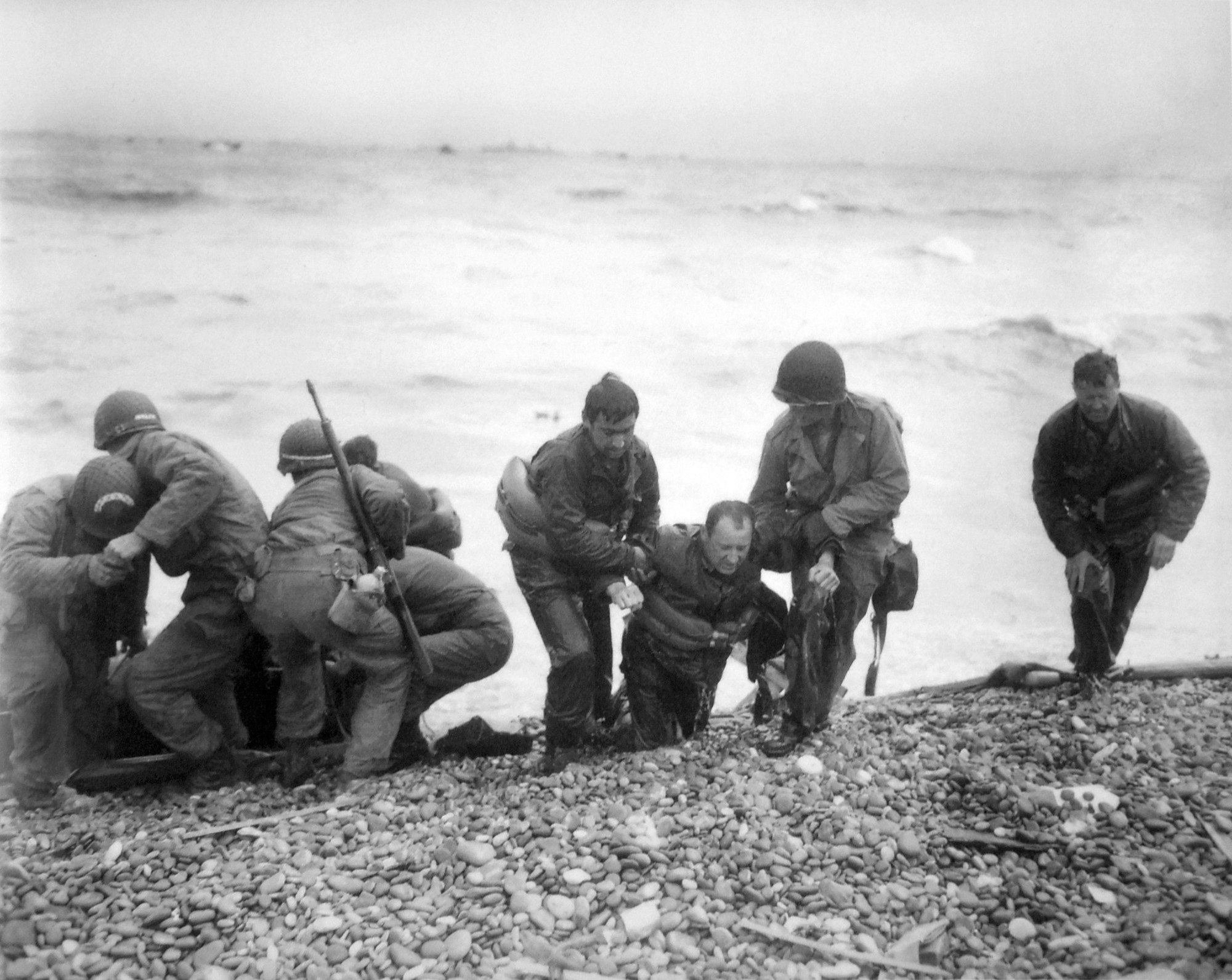 1944, Frankreich, Sainte-Mere-Eglise: Soldaten einer amerikanischen Landeeinheit helfen ihren Kameraden während der Landung der alliierten Truppen an Land.