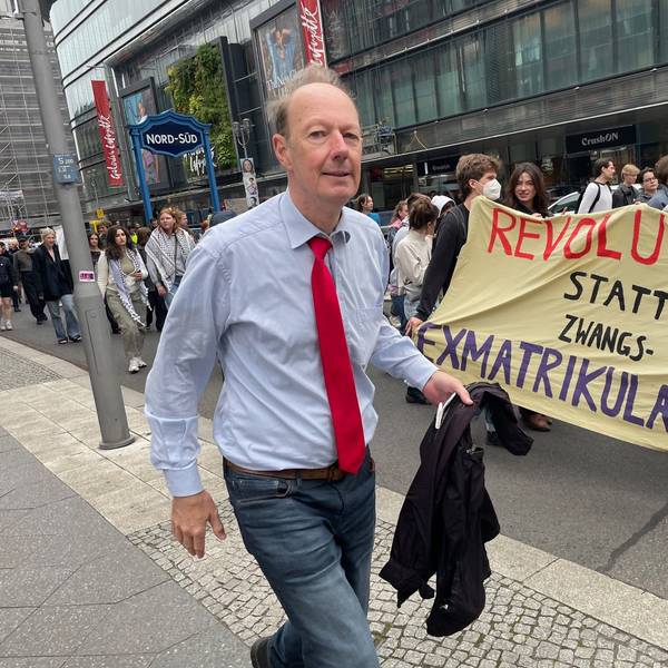 Martin Sonneborn geht in Berlin an Demonstranten vorbei.