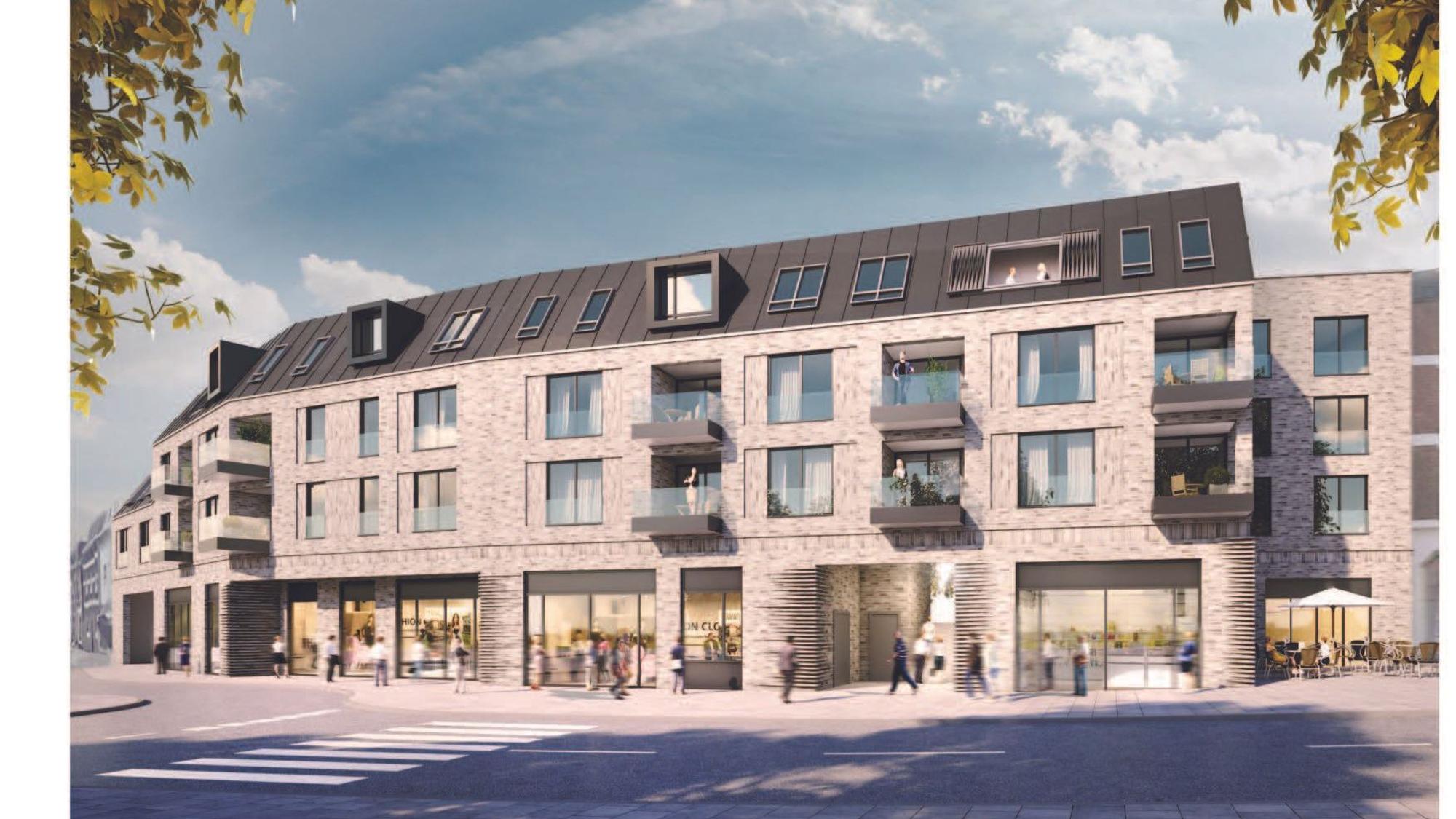Ein Gebäude mit einer verklinkerten Fassade, im Erdgeschoss Ladenlokale.