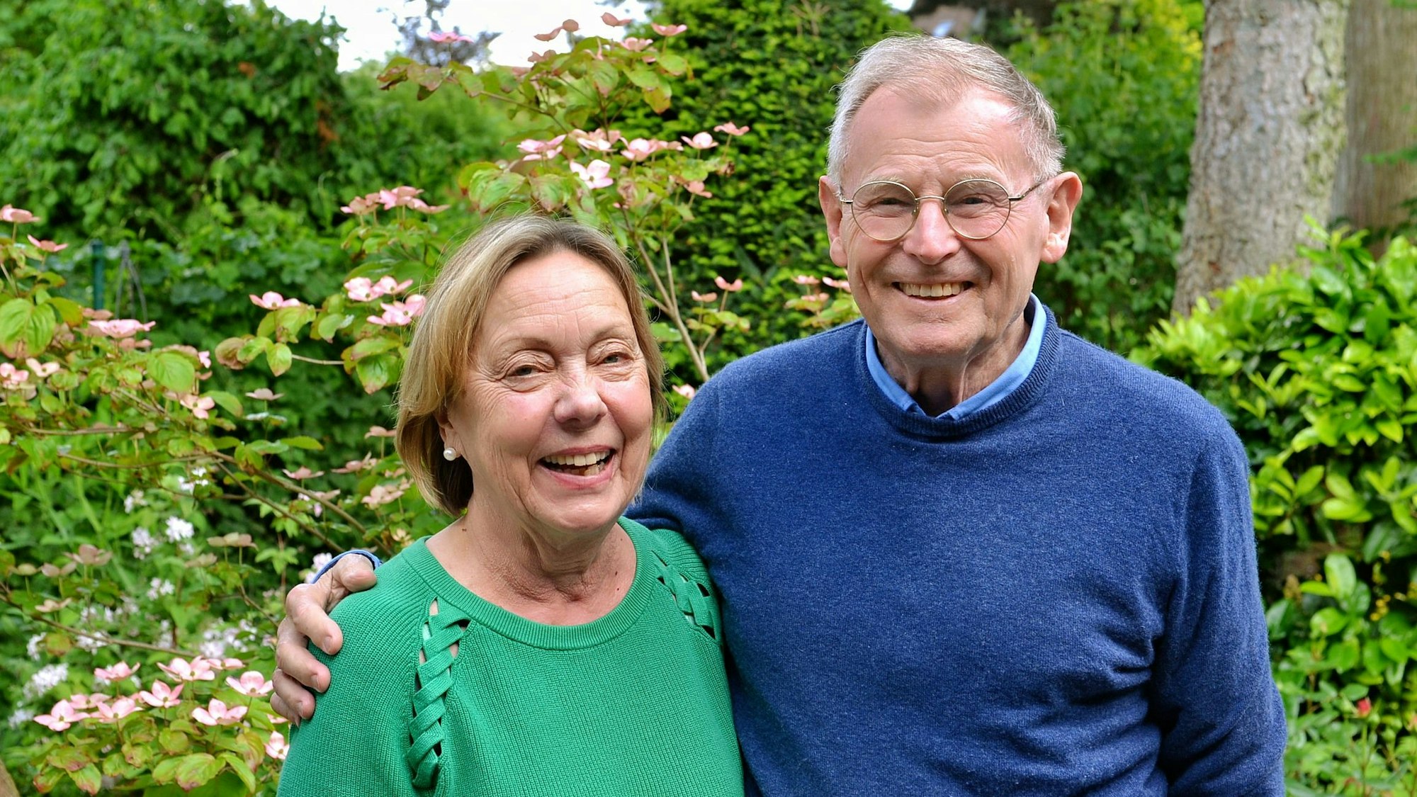 Karlheinz Schrade und seine Ehefrau Barbara Schrade stehen in ihrem Garten und halten sich im Arm.