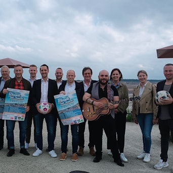 Frauen und Männer halten Plakate mit dem Programm des Festivals in die Kamera.