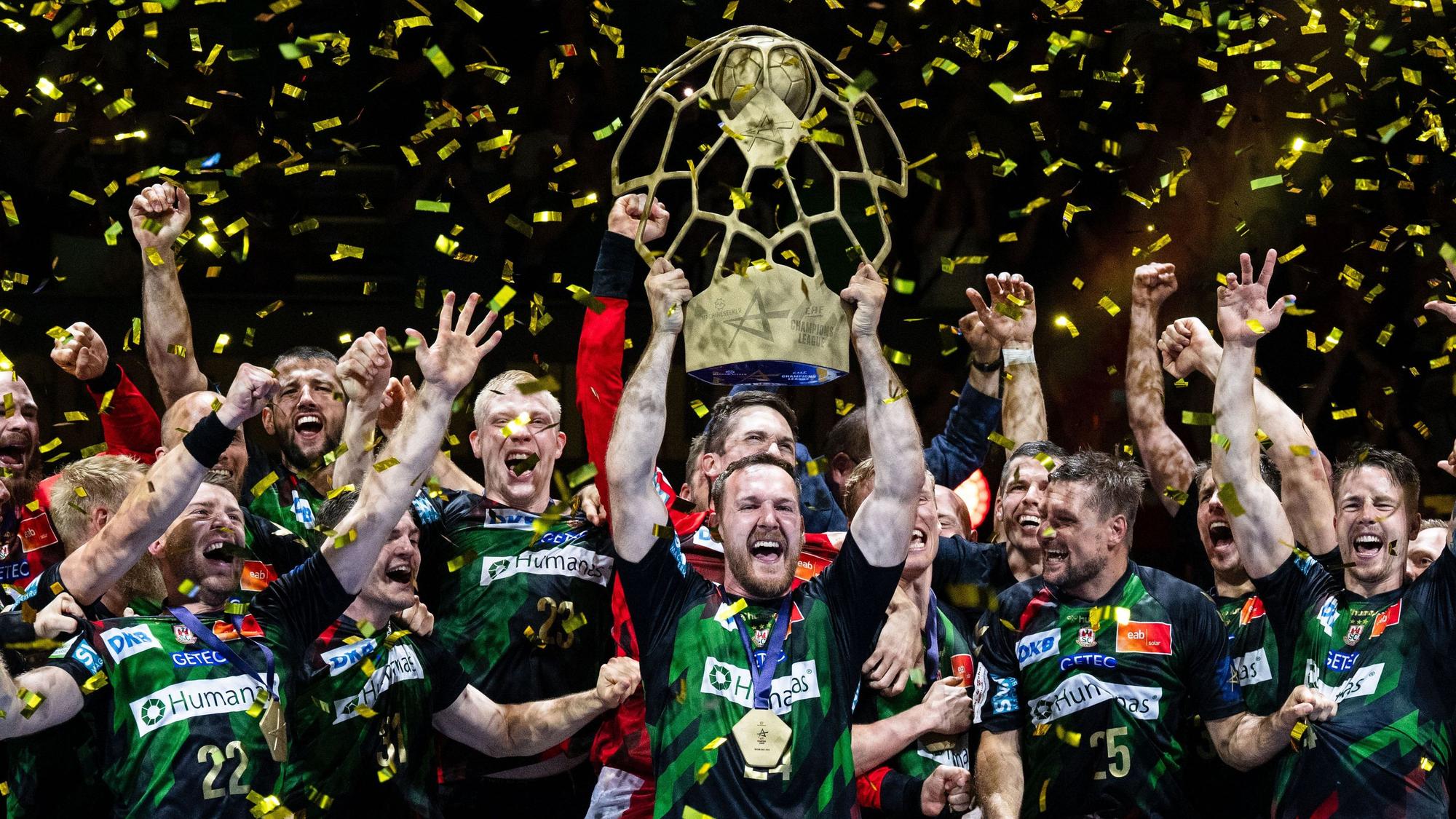 Die Spieler des SC Magdeburg um Christian O'Sullivan jubeln mit dem Pokal.