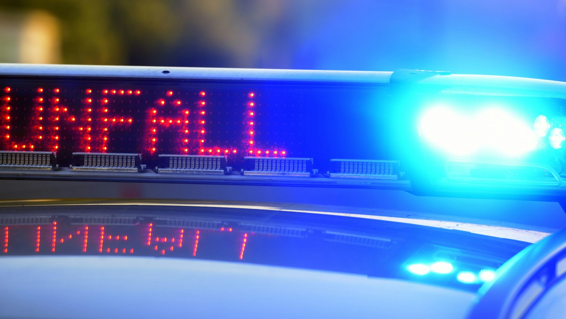 Das Bild zeigt den Schriftzug Polizei auf einem Streifenwagen.