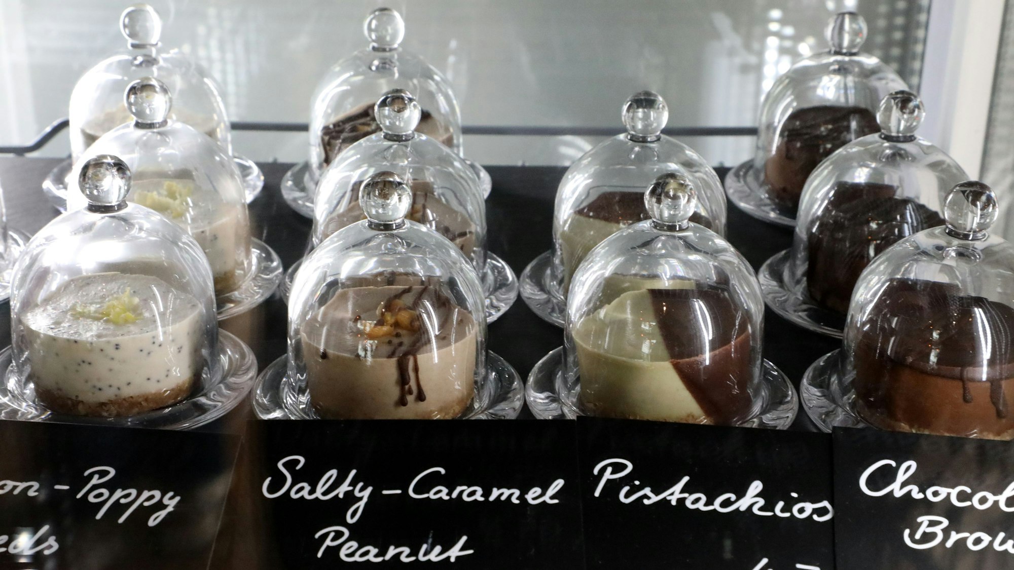 Törtchen, so genannte Raw Cakes, stehen in einem gläsernen Kühlschrank im Café Esperanza in Rösrath-Forsbach.