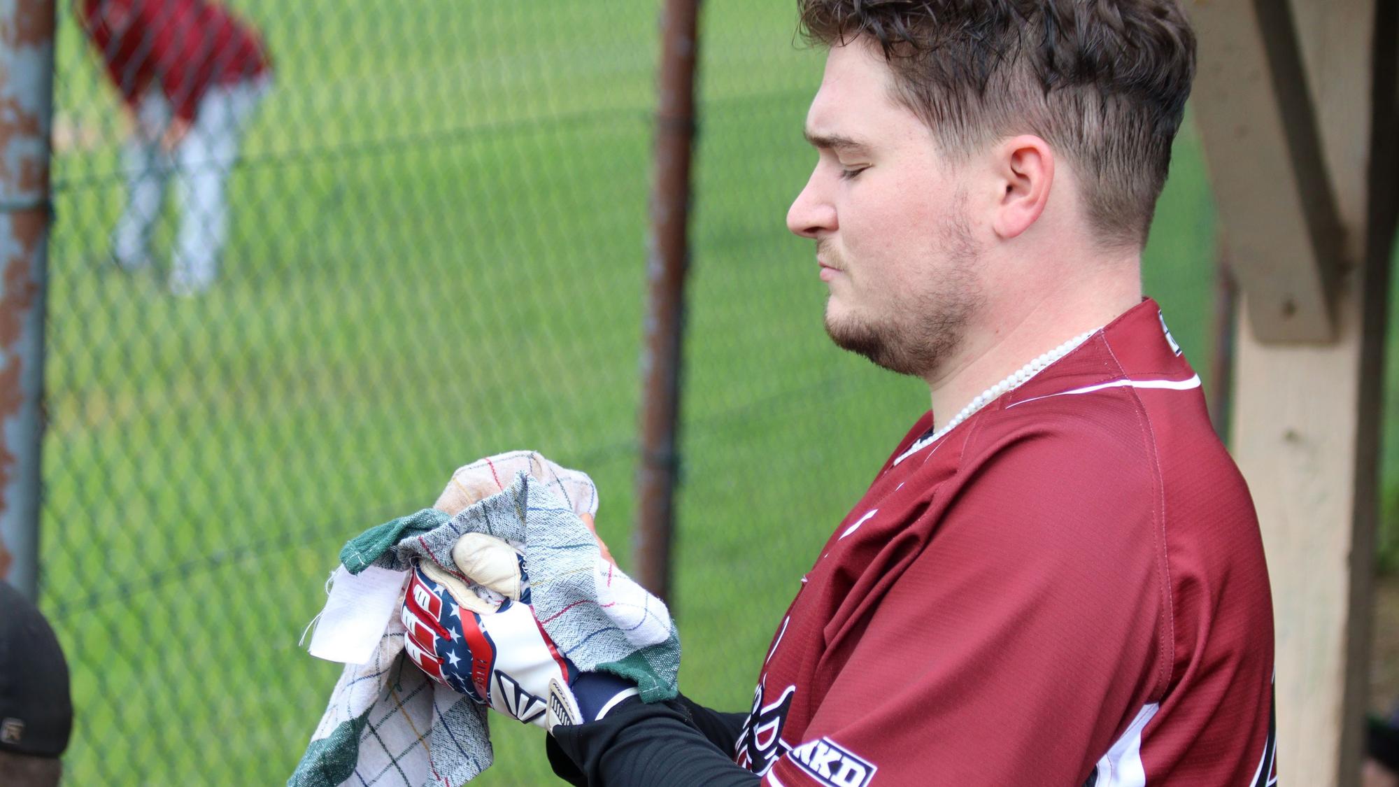 Ein Baseballspieler trocknet einen Ball mit einem Küchenhandtuch.
