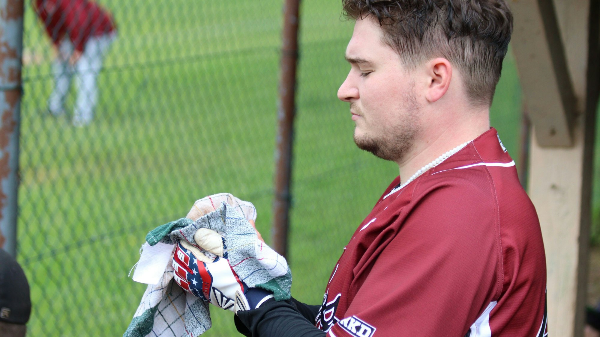 Ein Baseballspieler trocknet einen Ball mit einem Küchenhandtuch.