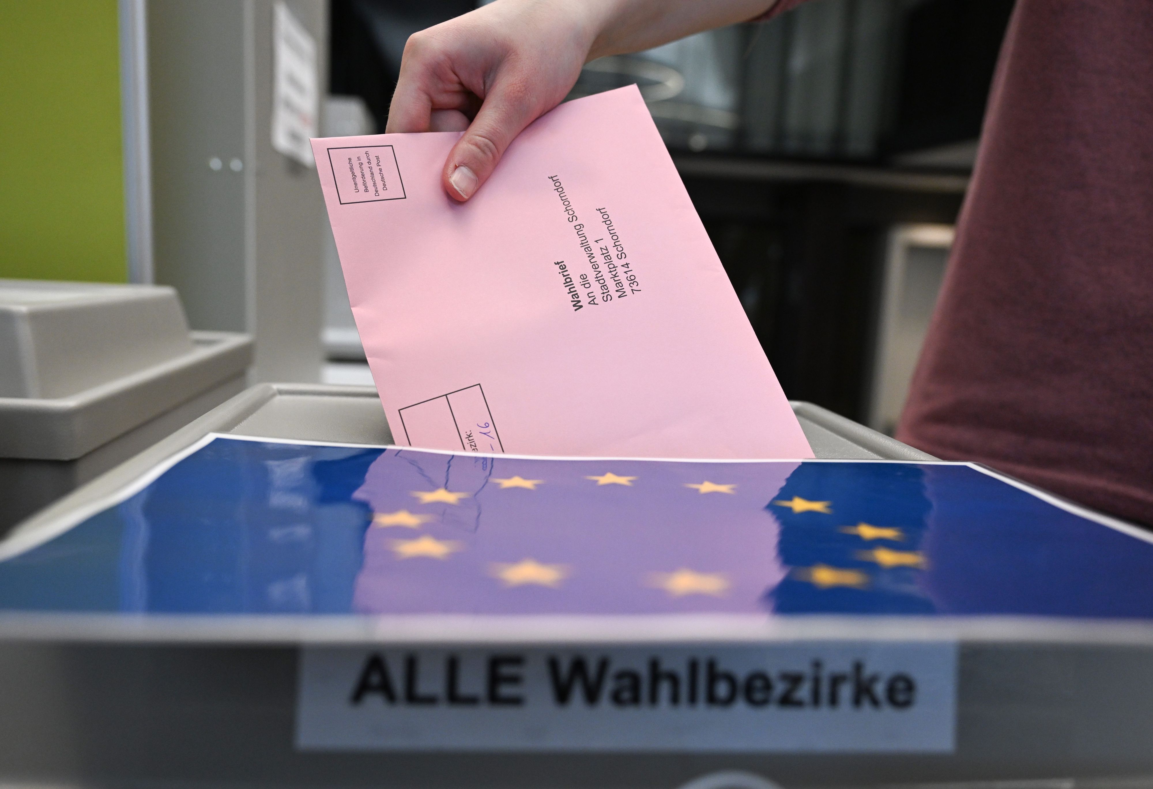 Auf dem Foto ist zu sehen, wie jemand seinen Wahlbrief in eine Wahlurne wirft.