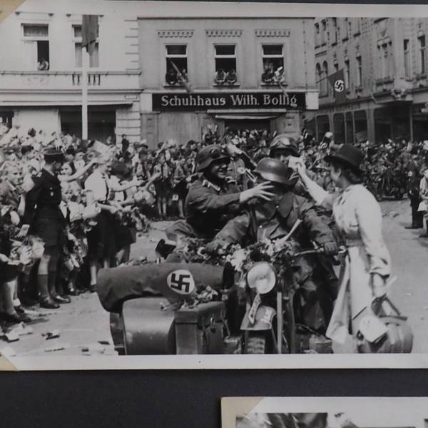 Soldaten auf einem Motorrad mit Beiwagen fahren auf den Euskirchener Marktplatz. Am Rand stehen jubelnde Menschen.