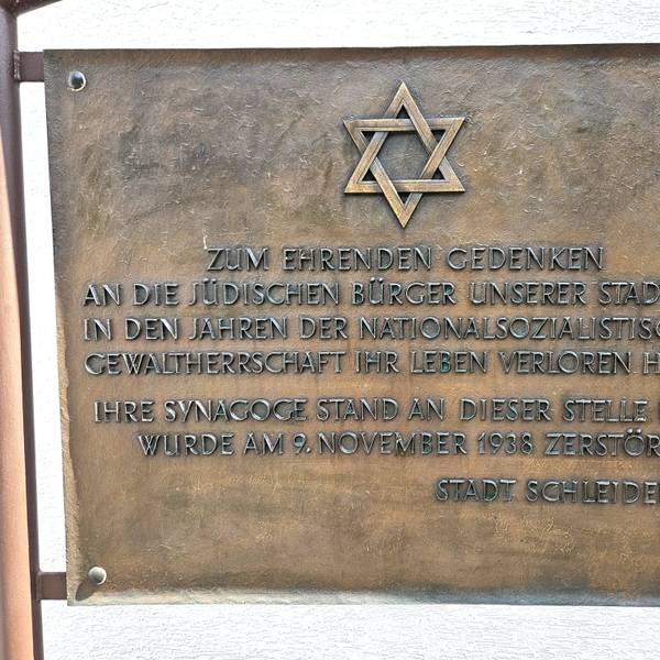 Eine Bronzetafel erinnert mit einem Davidstern und einer Inschrift an die zerstörte Synagoge und die in der NS-Zeit getöteten jüdischen Gemünder.