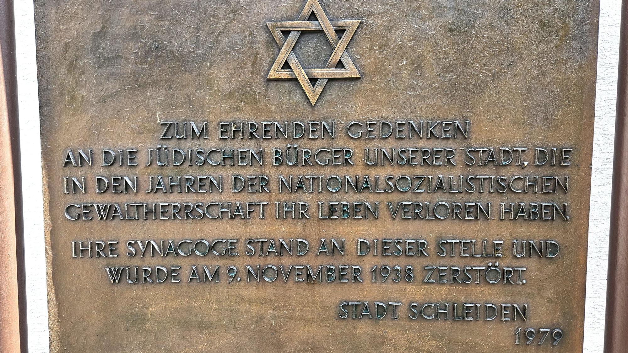 Eine Bronzetafel erinnert mit einem Davidstern und einer Inschrift an die zerstörte Synagoge und die in der NS-Zeit getöteten jüdischen Gemünder.