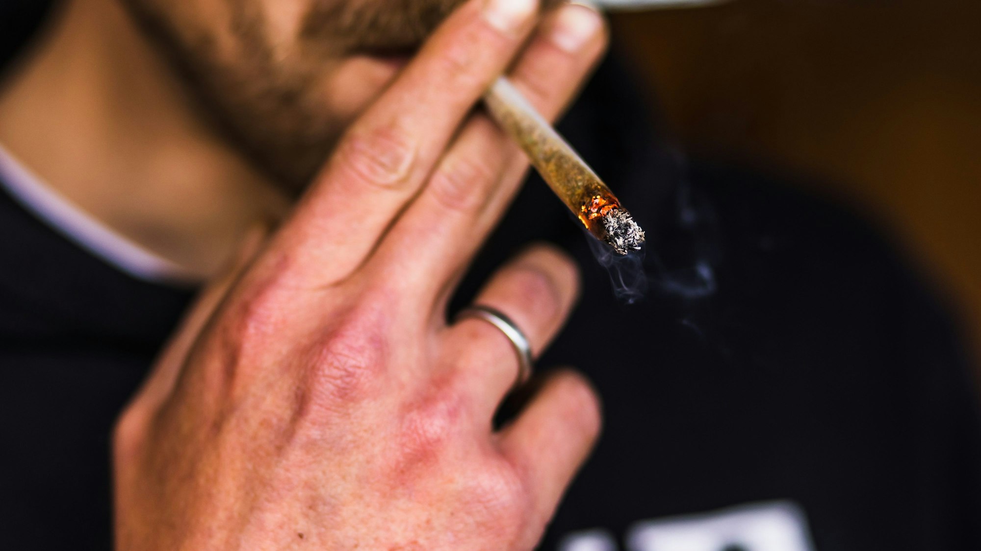 Ein Mann zieht an einem Joint.