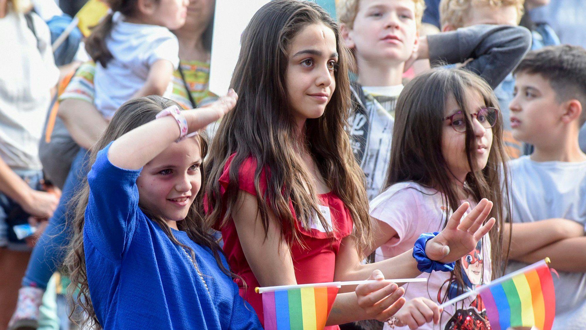 Auf dem Bild sind Mädchen zu sehen, die das Bühnenprogramm verfolgen.