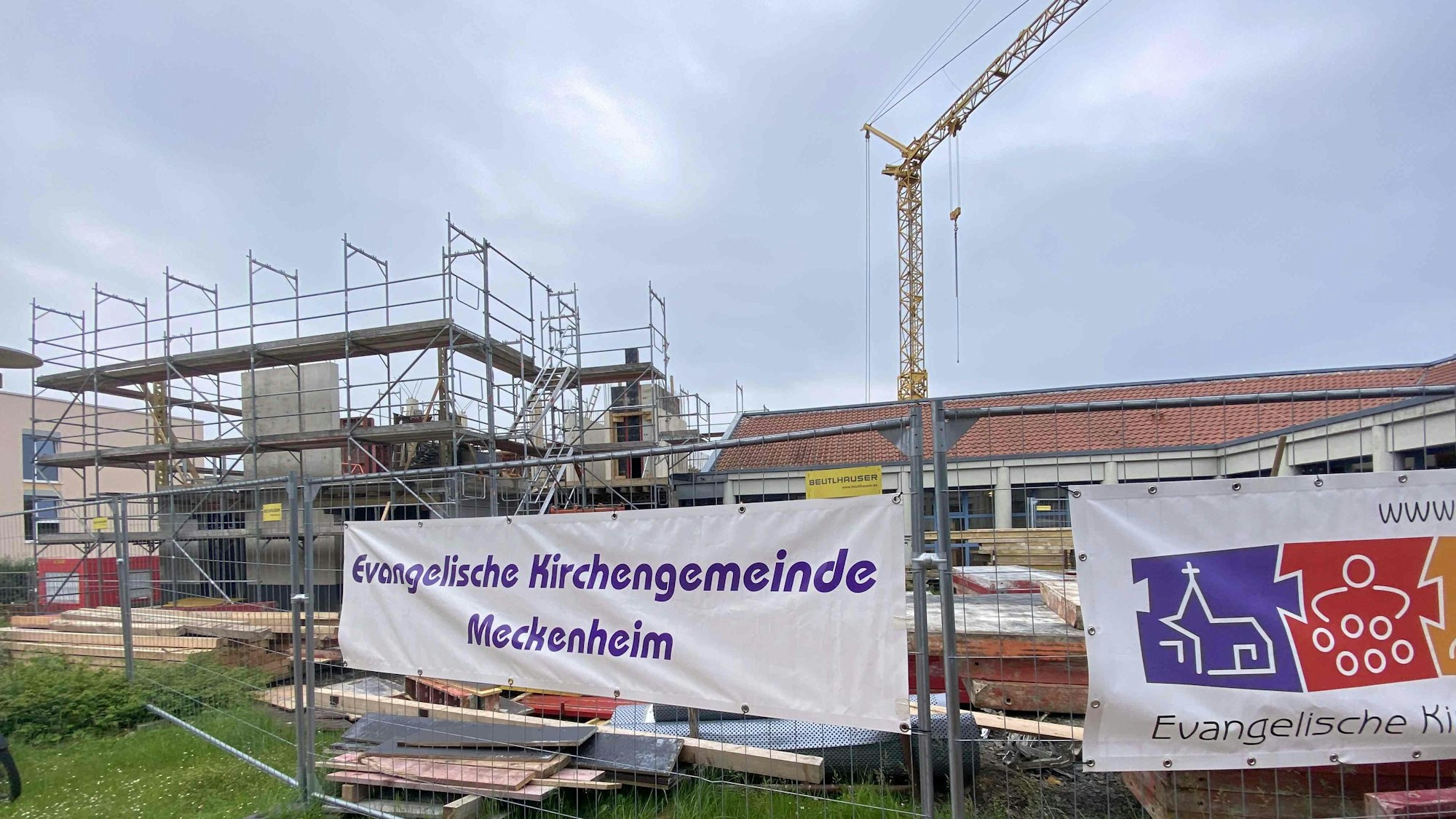 Der Kran dreht sich auf der Baustelle am Gemeindezentrum Friedenskirche in Meckenheim, die Arbeiten schreiten fort.