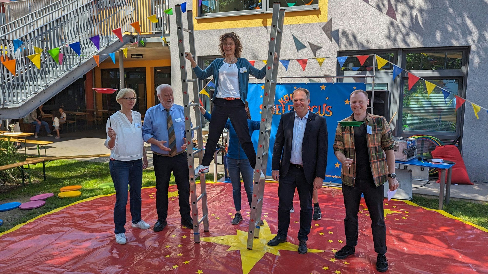 Die Jubiläumsgäste haben Spaß in der Manege des Kölner Spielecircus auf dem Außengelände der Kita.