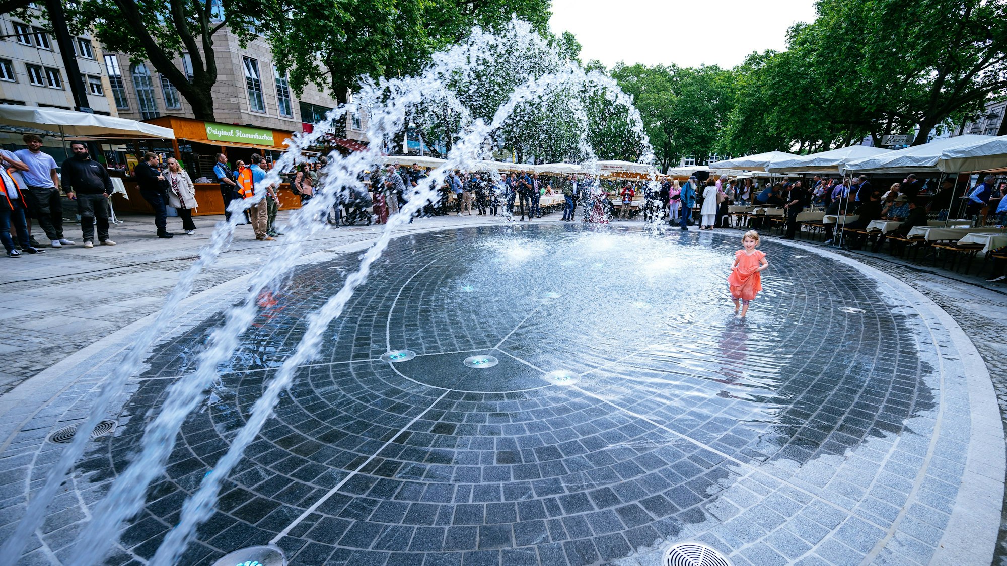 Das neue Wasserspiel am Neumarkt sprudelt und lockte gleich den ersten jungen Badegast an.