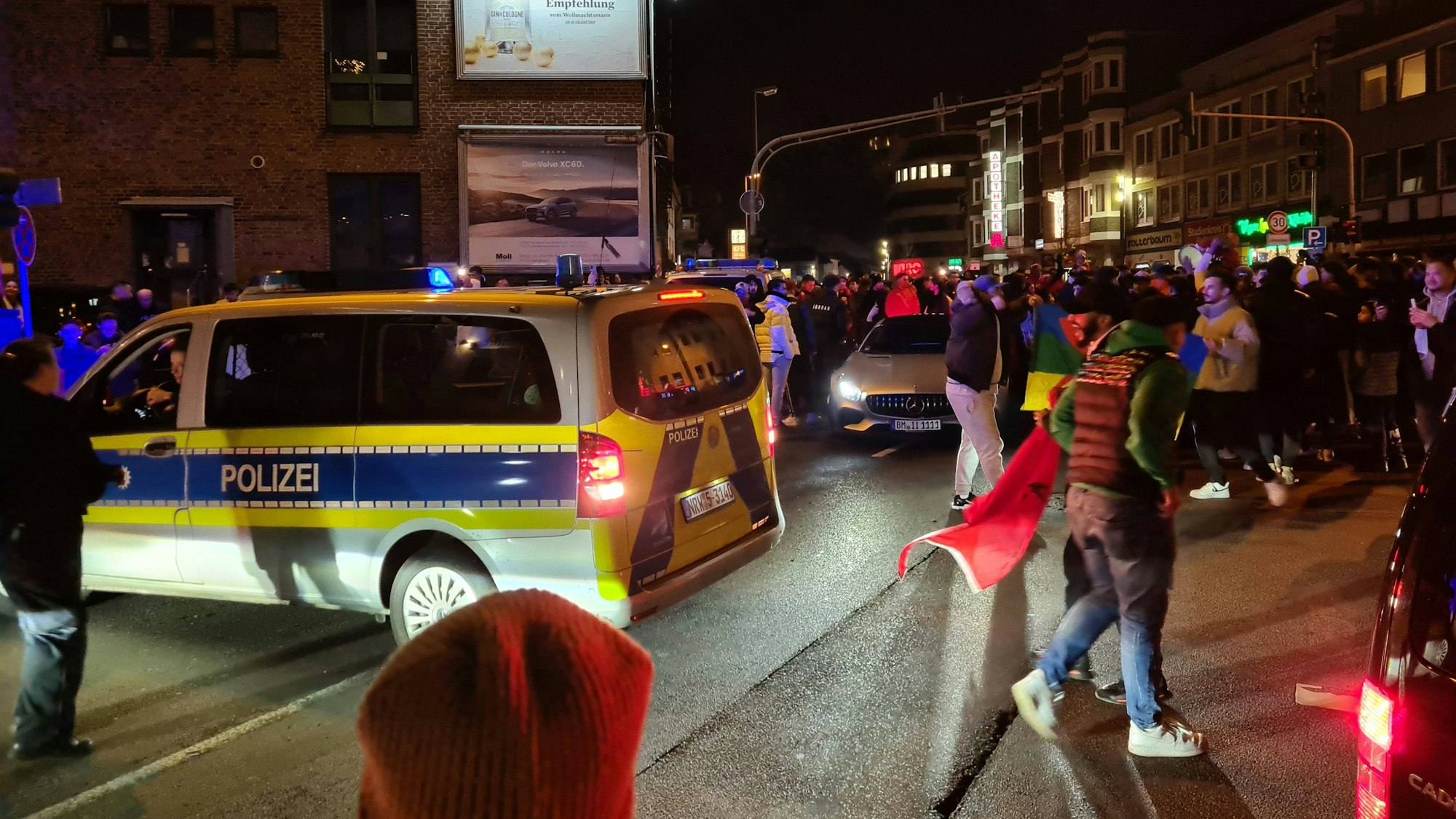 Auf dem Foto sind feiernde marokkanische Fans in der Bergheimer Innenstadt nach einem Sieg ihrer Mannschaft bei der WM 2022 und Polizisten zu sehen.