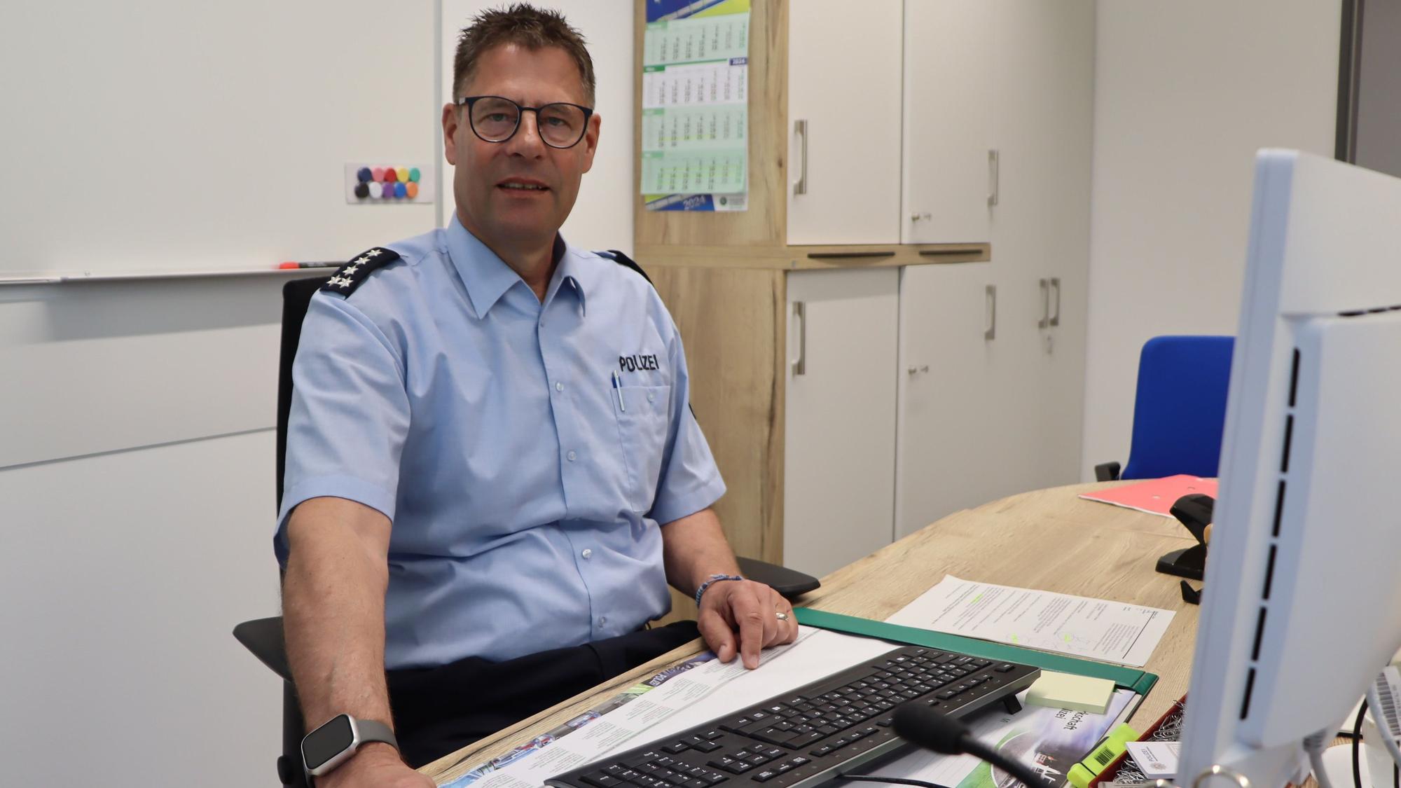 Auf dem Foto ist der Polizeibeamte Uwe Bellmann an seinem Schreibtisch zu sehen.