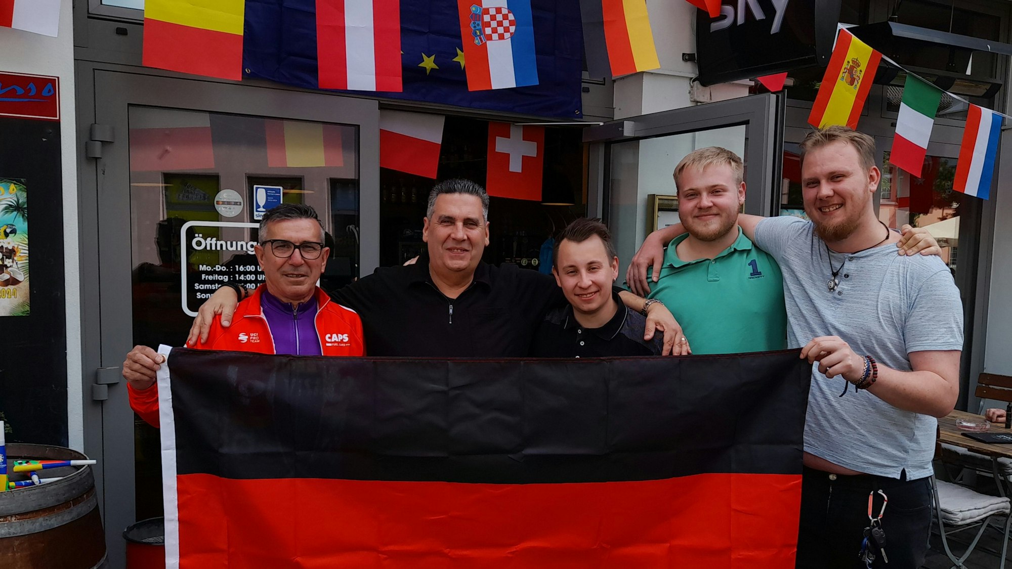 Das Team vom „Picasso“ in Hoffnungsthal steht mit einer Deutschlandfahne zur EM vor dem Lokal.